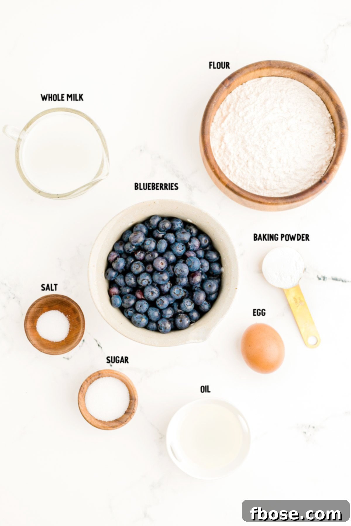 Overhead photo of ingredients prepped to make blueberry pancakes on a marble counter.