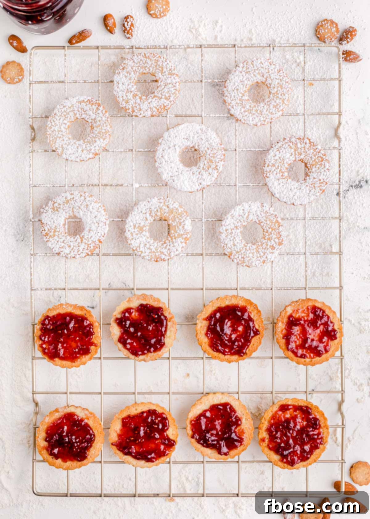 Berry-Filled Linzer Delights 13 Linzer cookie halves being prepared on a wire rack.