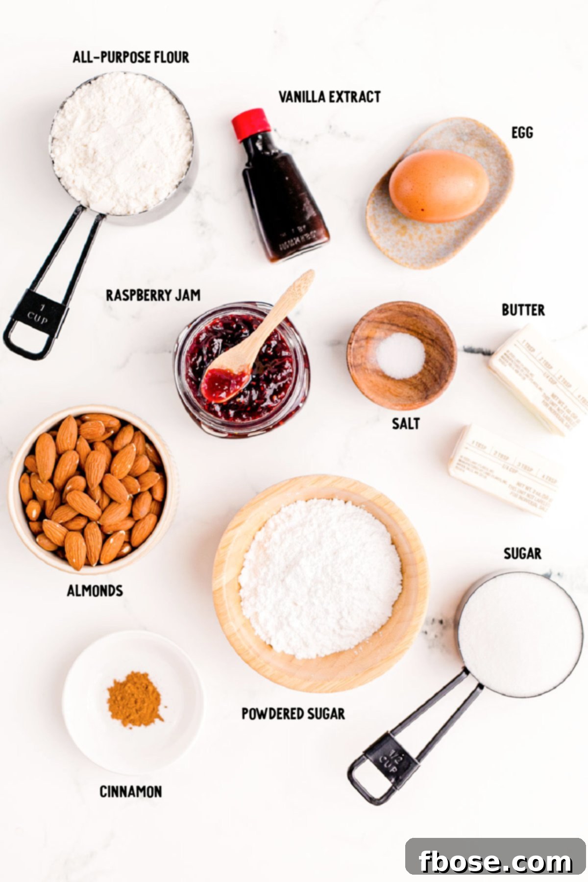 Berry-Filled Linzer Delights 4 Overhead photo of ingredients to make linzer cookies on a white marble surface.