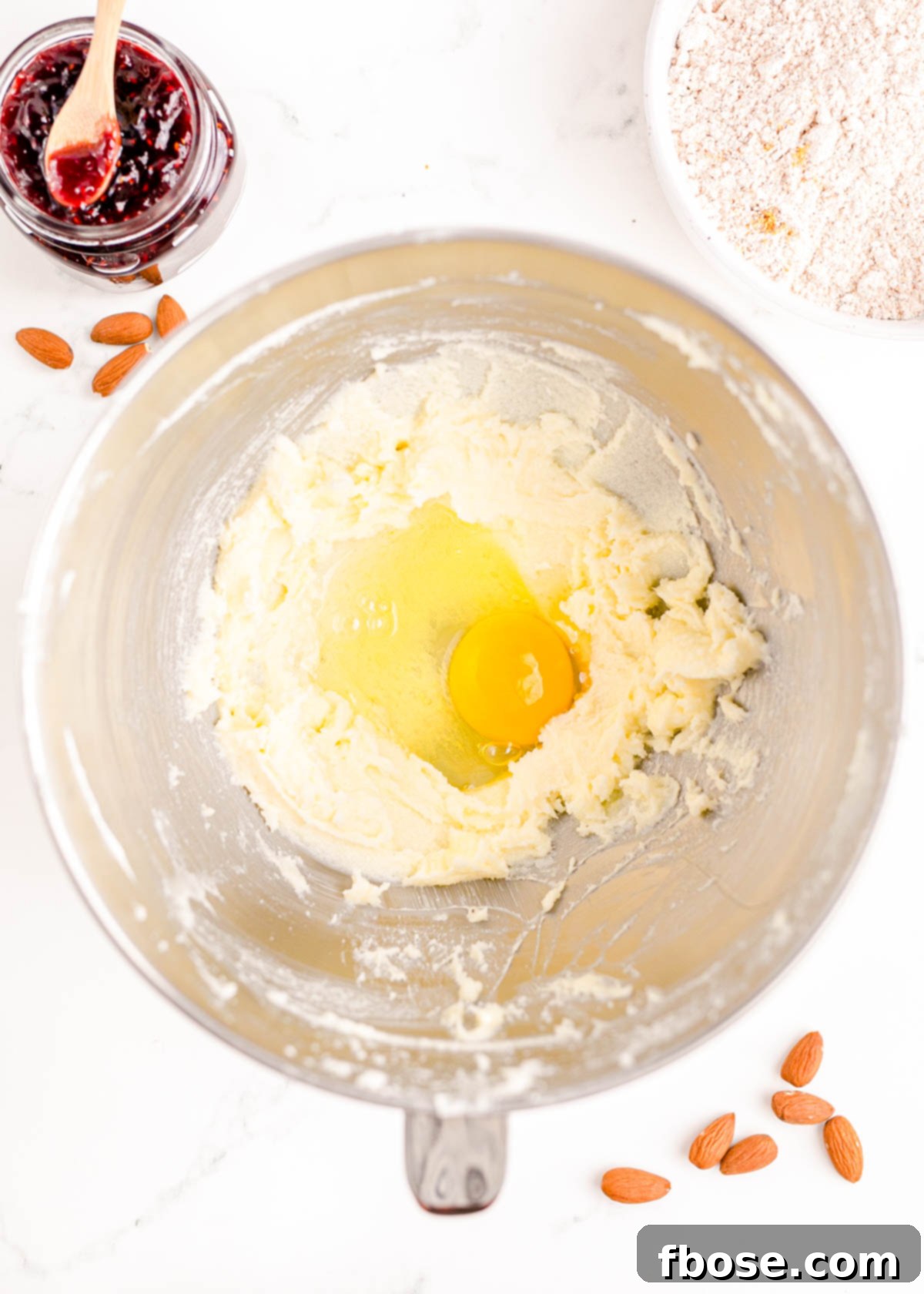 Berry-Filled Linzer Delights 8 An egg added to a stand mixer bowl ready to be beaten into cookie dough.