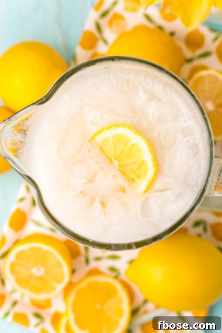 Overhead photo of a pitcher of creamy lemonade surrounded by lemons.