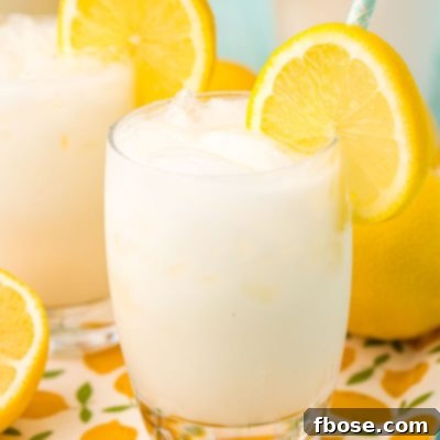 Close up photo of a glass filled with ice and creamy lemonade.