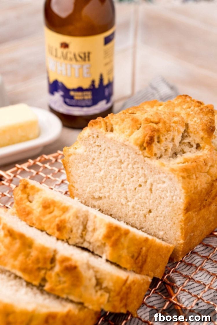 Simple & Delicious Beer Bread 6 A loaf of beer bread on a copper wire rack that has been sliced.