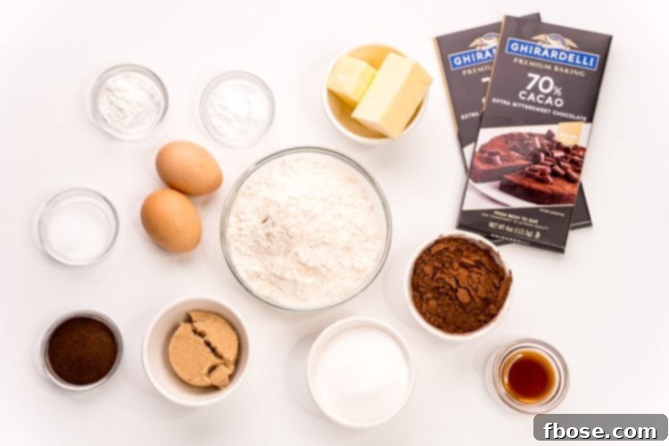Assorted ingredients like chocolate chips, butter, sugars, and flour, neatly arranged on a pristine white table, ready for baking dark chocolate sugar cookies.
