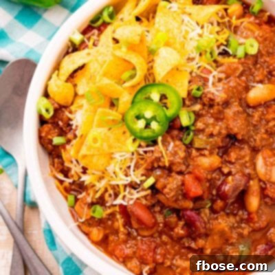 Ultimate Slow Cooker Chili 7 Overhead photo of a bowl of slow cooker chili on a teal gingham napkin.