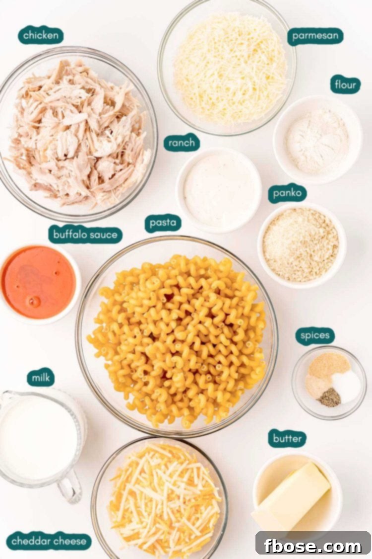 Overhead photo of ingredients prepped to make buffalo chicken mac and cheese on a white surface.