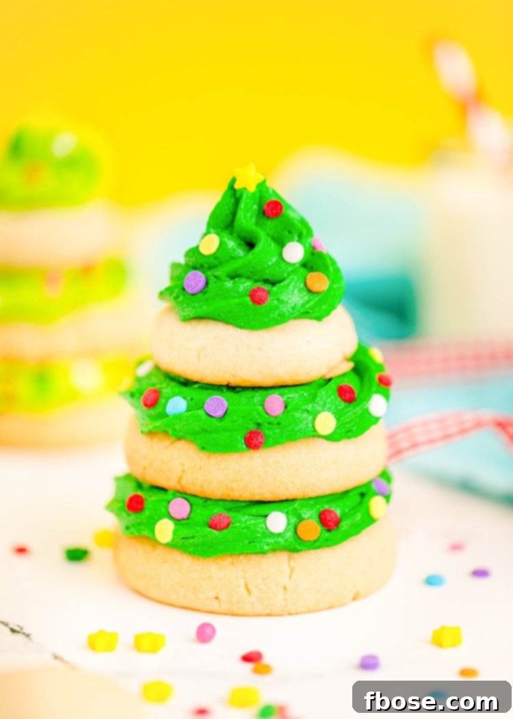 Festive Fir Tree Treats 2 Close up photo of a stunning Christmas tree cookie, meticulously crafted with stacked sugar cookies and rich green frosting, presented on a pristine white surface against a warm yellow background.