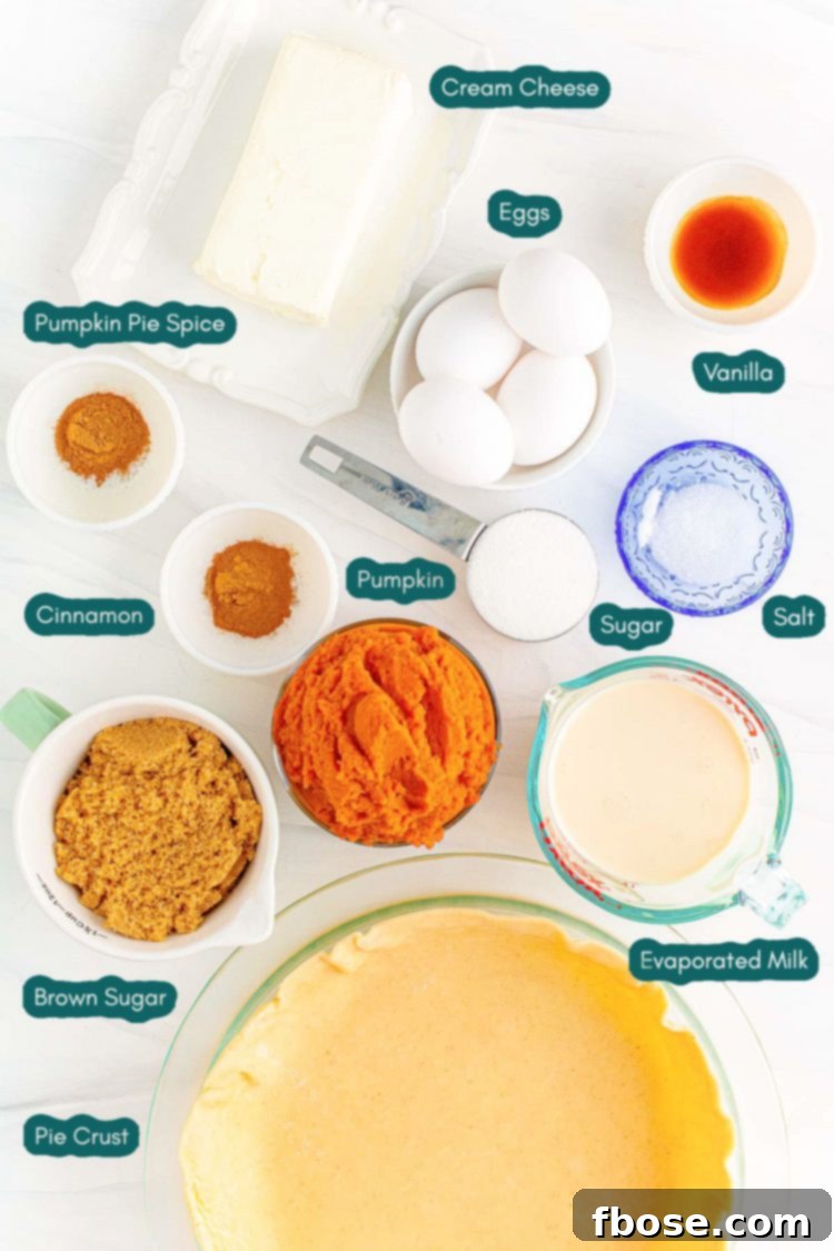 Ingredients to make pumpkin cheesecake pie prepared on a marble counter.