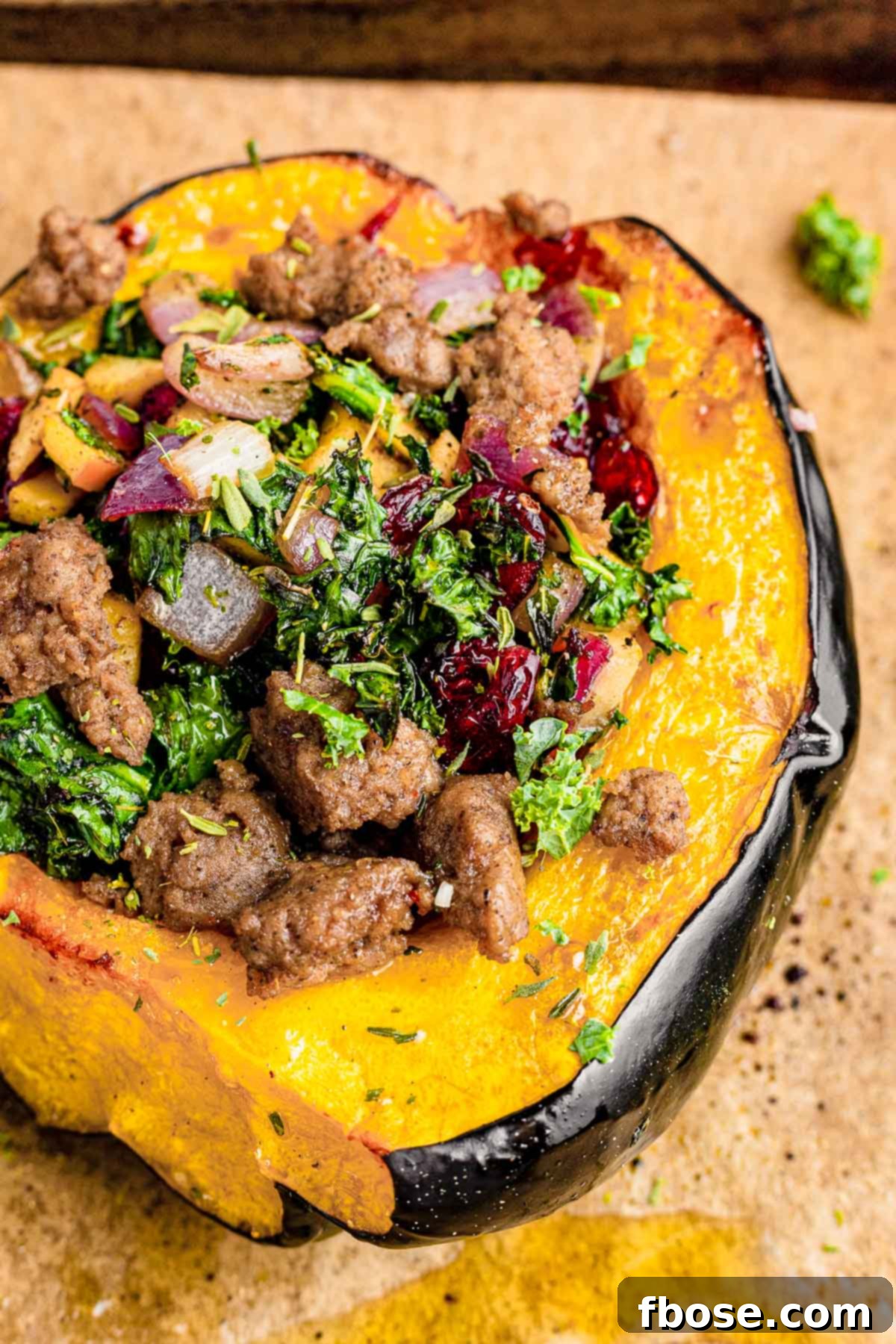 Close up photo of stuffed acorn squash on parchment paper.