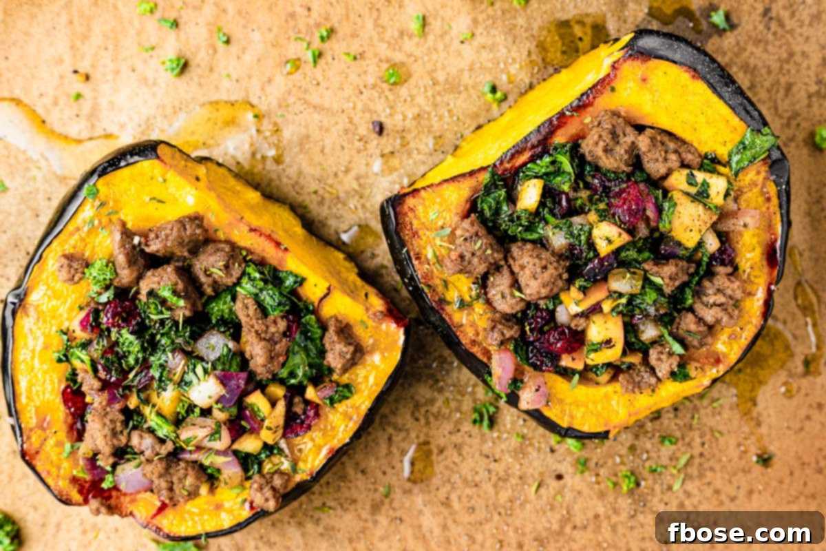 Stuffed acorn squash halves on a baking sheet lined with parchment paper.