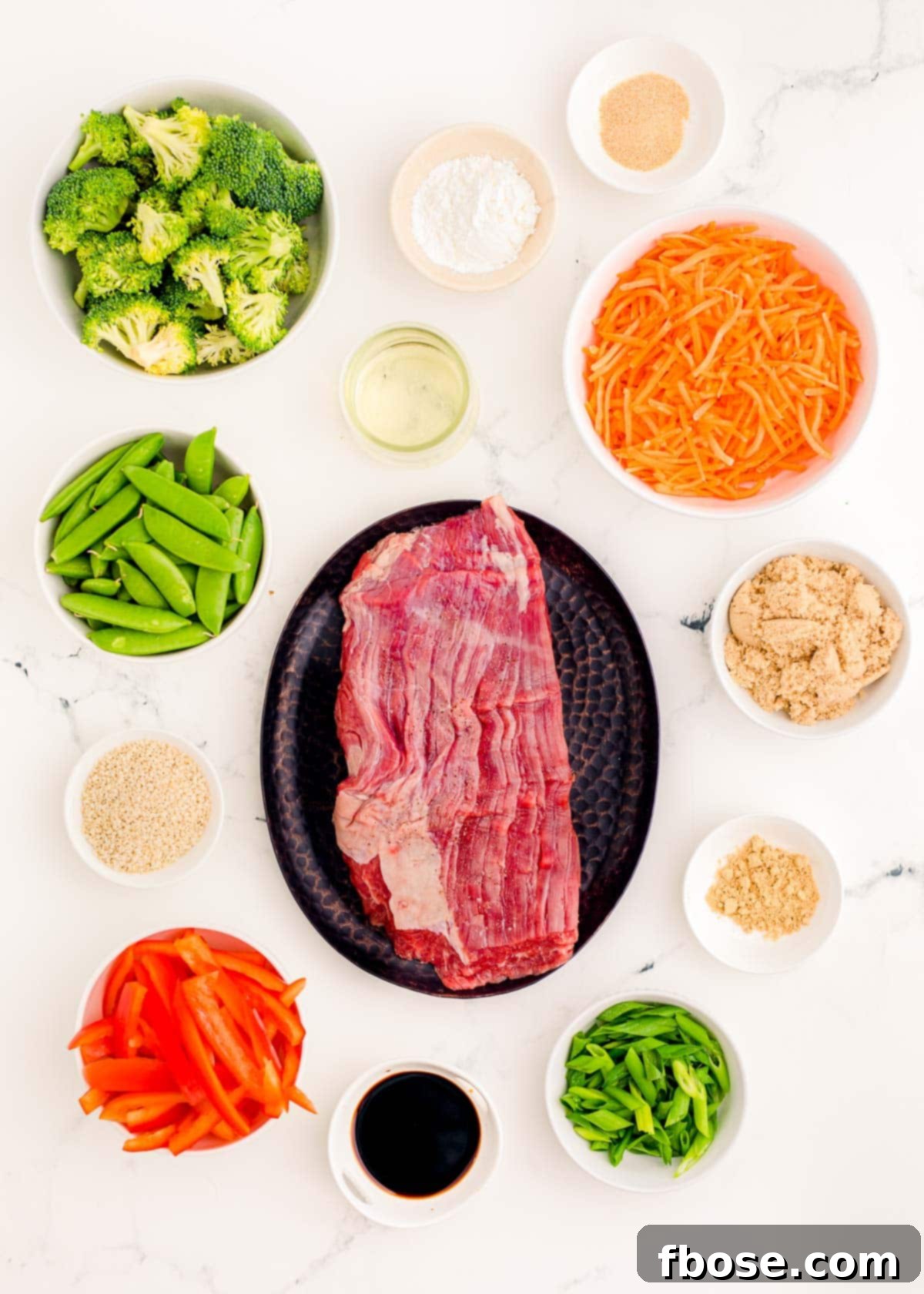 Beef stir fry ingredients on a marble table.