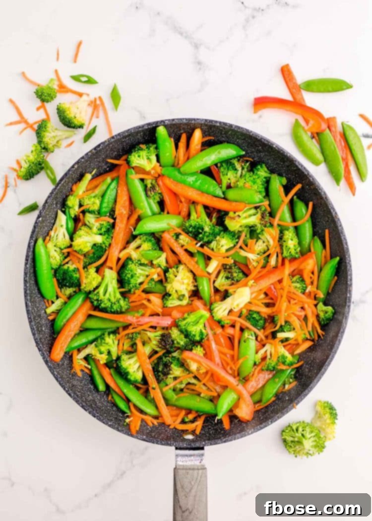 Vegetables being sauteed in a skillet.