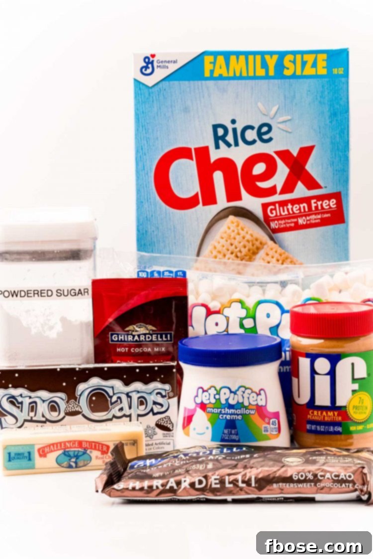 Ingredients laid out on a white table including Rice Chex, chocolate chips, butter, peanut butter, marshmallow creme, hot cocoa mix, powdered sugar, mini marshmallows, and Snow Caps.