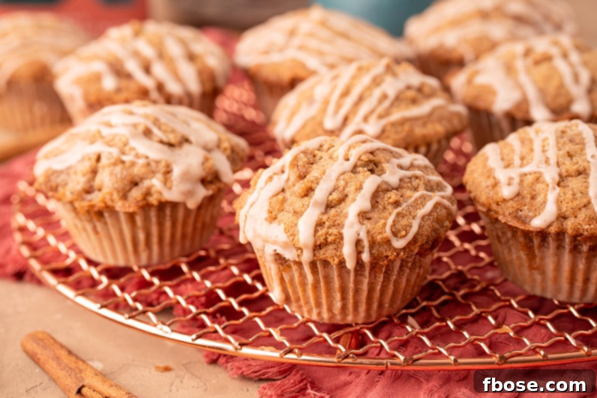 A close-up of a stack of golden-brown vanilla chai muffins, garnished with a generous drizzle of sweet glaze, ready to be enjoyed.