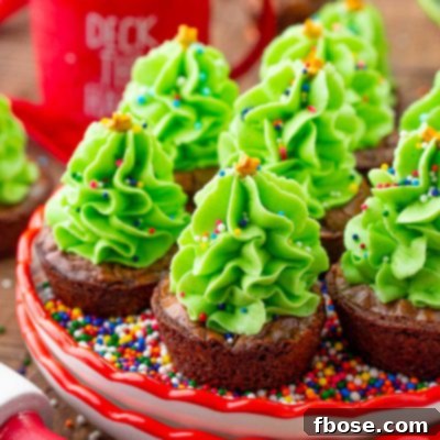 Close up photo of christmas tree brownie bites on a small plate filled with rainbow sprinkles.