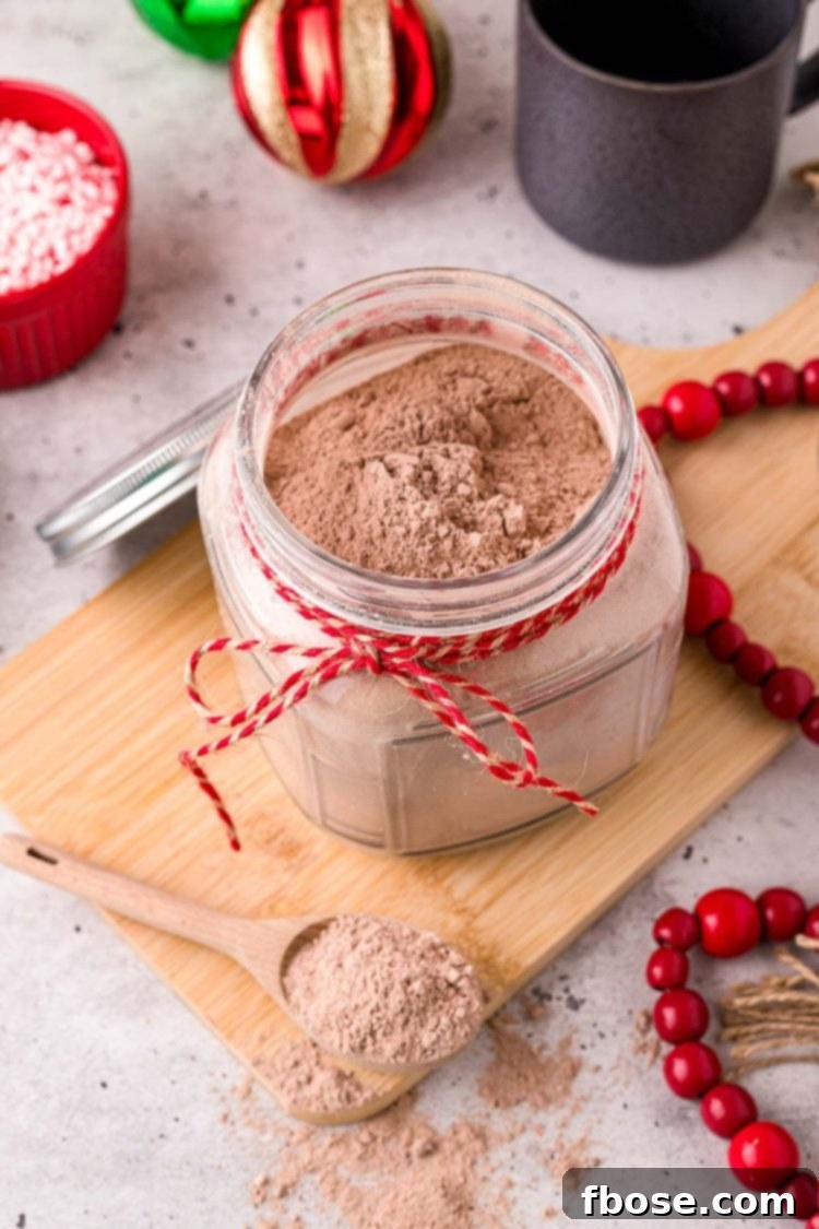 Close up photo of a jar with homemade hot chocolate mix in it with a baking twine ribbon around the neck of the jar.