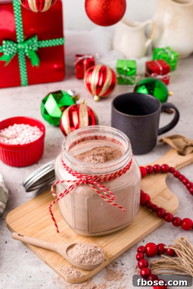 Close up photo of a jar with homemade hot chocolate mix in it with a baking twine ribbon around the neck of the jar.
