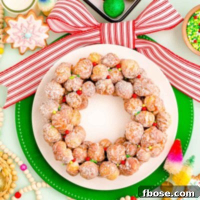 Overhead photo of a donut hole platter designed to look like a christmas wreath with holiday decorations scattered around it.