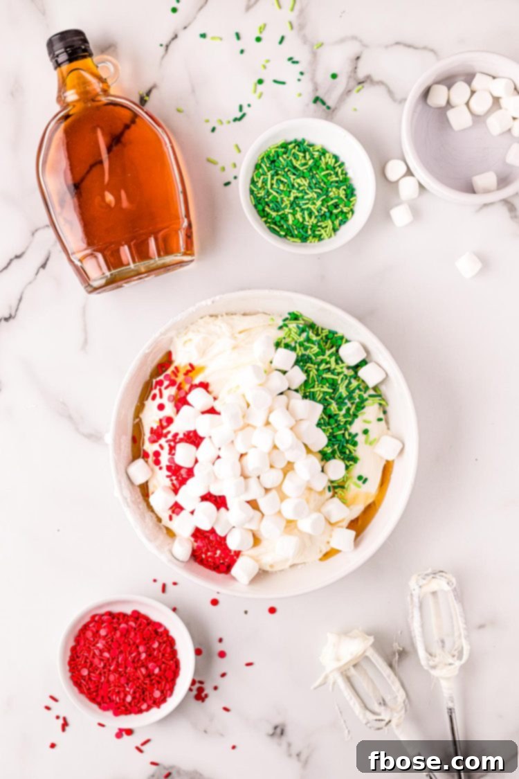 Overhead photo of a Christmas dip being made in a white bowl on a marble surface.