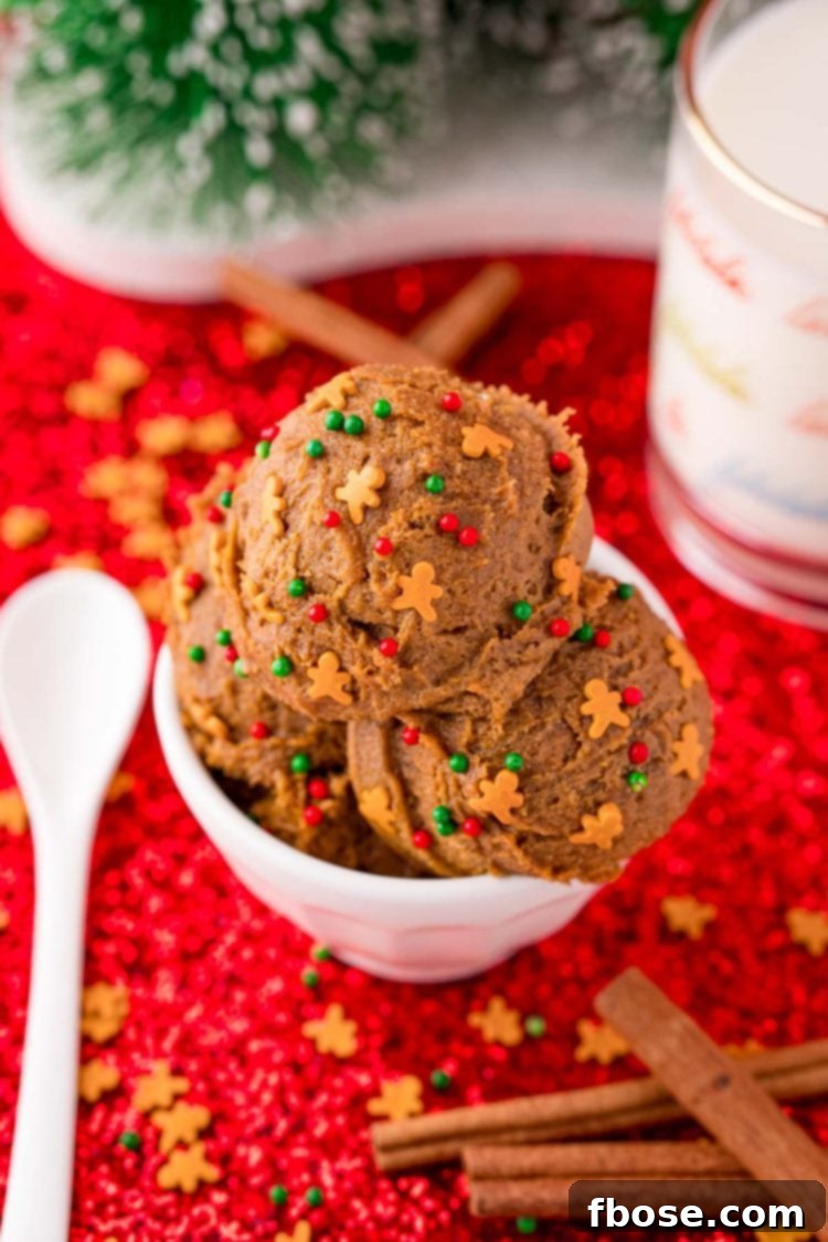 No Bake Gingerbread Cookie Dough 3 A bowl of edible gingerbread cookie dough on a red surface with cinnamon sticks and a glass of milk next to it.