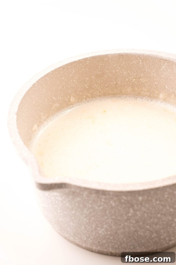 Milk and heavy cream being warmed in a small saucepot.
