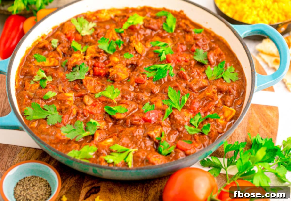 Effortless Madras Curry 4 A blue skillet filled with rich, red madras curry and chicken.