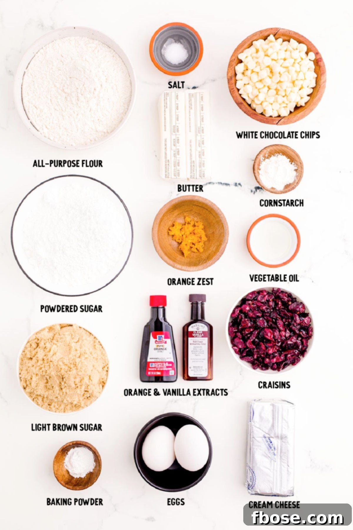 Overhead photo of all the meticulously prepped ingredients for making Cranberry Bliss Bars, neatly arranged on a sleek marble surface.