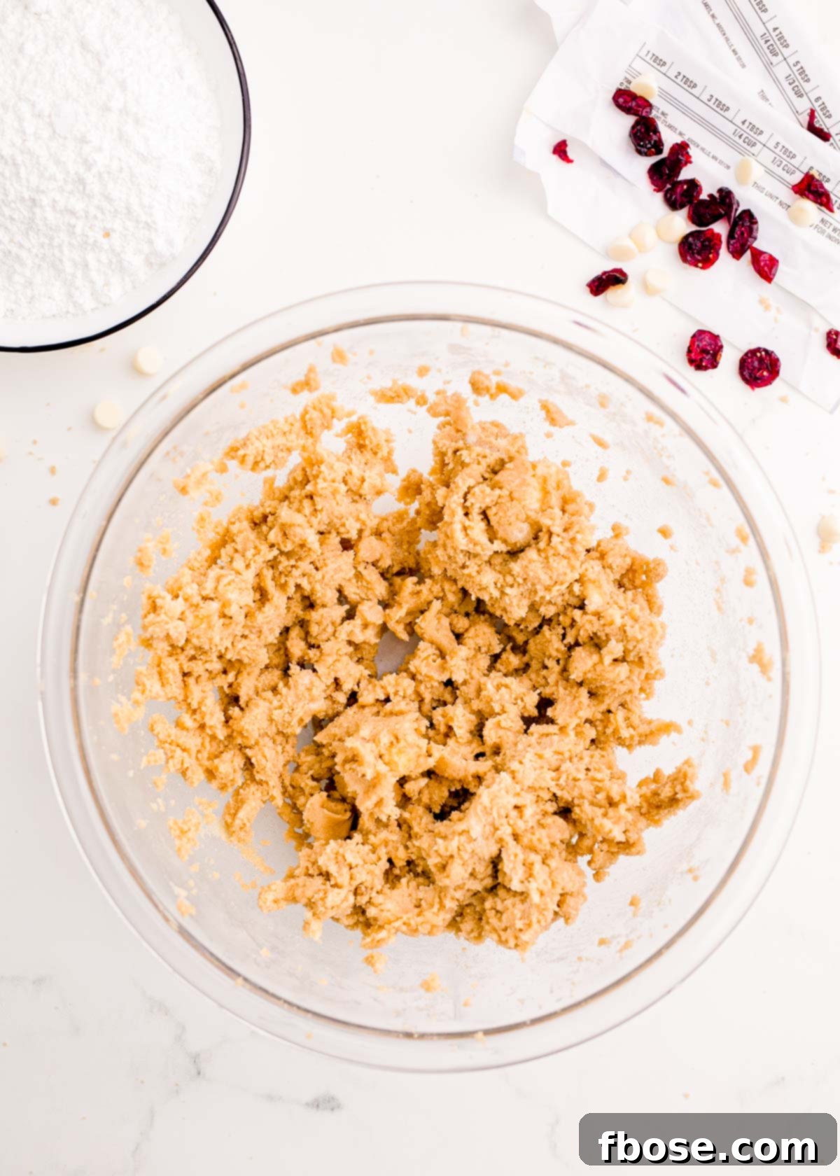 Softened butter and light brown sugar expertly creamed together in a spacious glass mixing bowl, showcasing a light and fluffy texture.