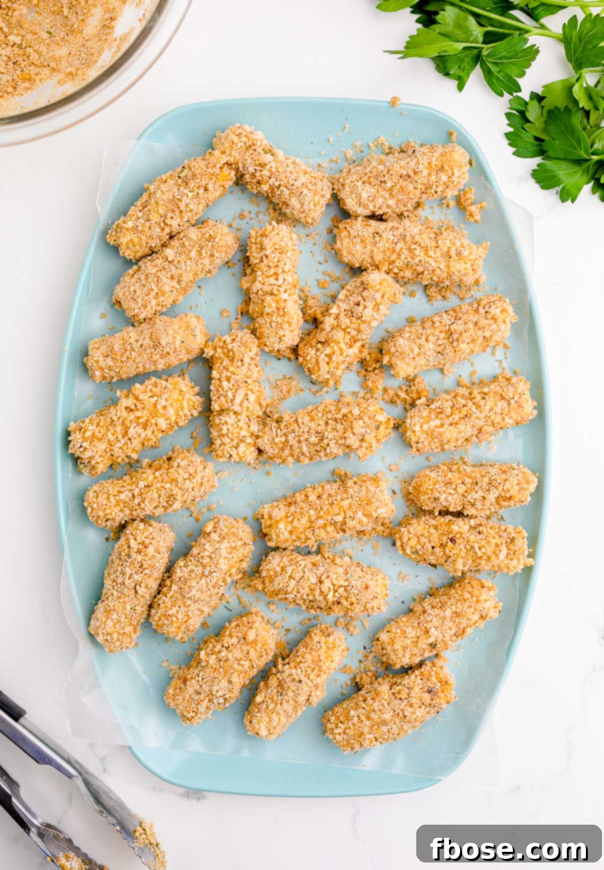 Overhead photo of mozzarella sticks on a blue plate.