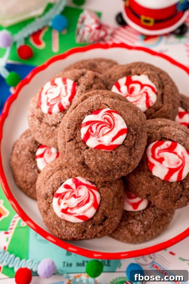 Mint Chocolate Thumbprint Treasures 3 Close up photo of chocolate peppermint cookies on a red trimmed plate.