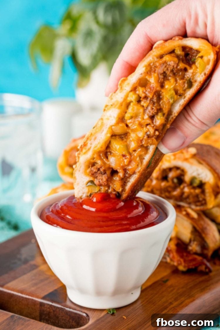 Easy Loaded Bread 6 A woman's hand holding a piece of garbage bread and dipping it in a bowl of ketchup.