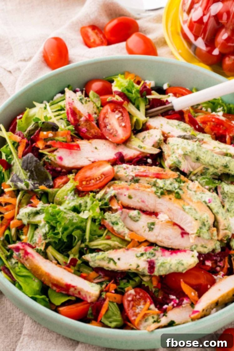 Close up photo of a grilled chicken salad with green goddess dressing.
