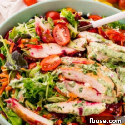Close up photo of a grilled chicken salad with green goddess dressing.