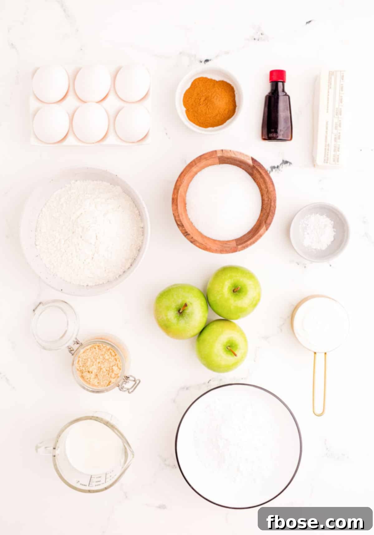 Ingredients to make apple fritter bread prepared on a marble surface, neatly arranged and ready for baking.