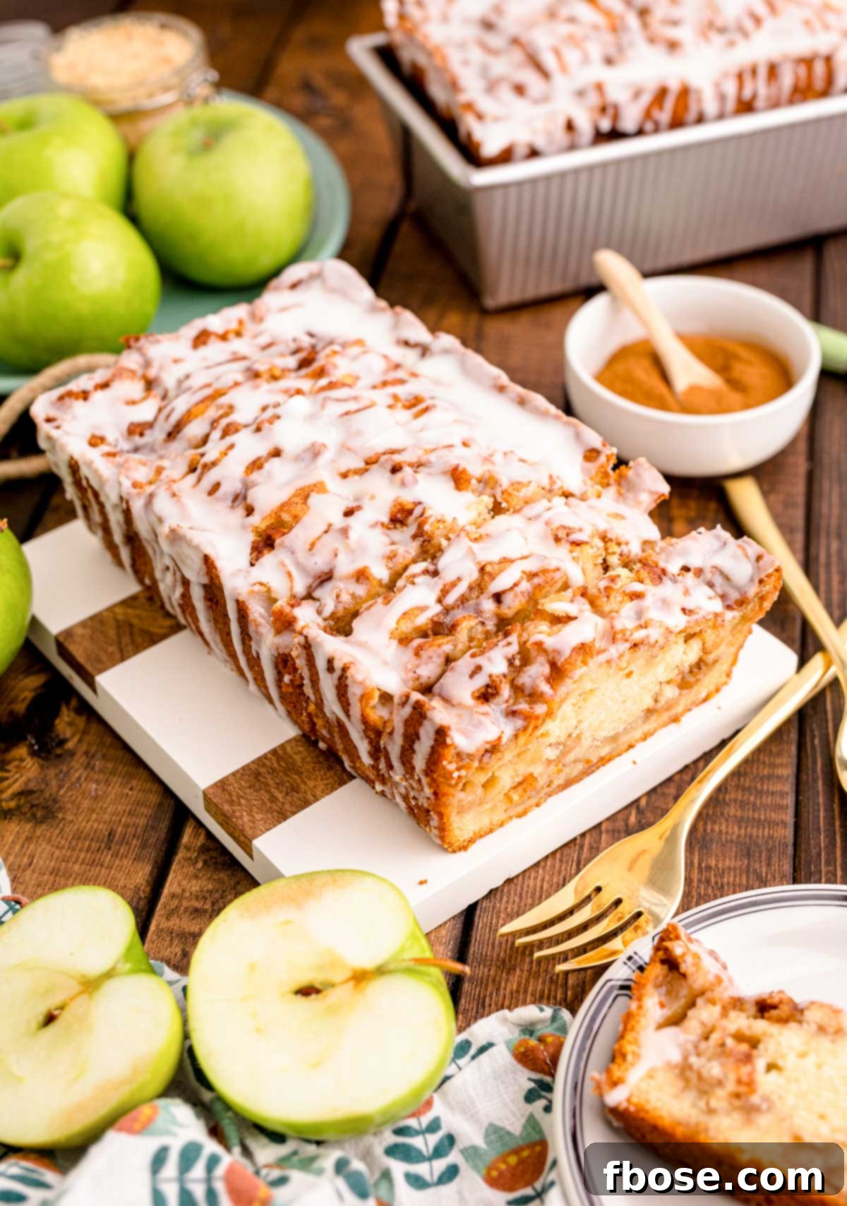 Close up photo of Apple Fritter Bread on a wood and marble cutting board, ready to be sliced.