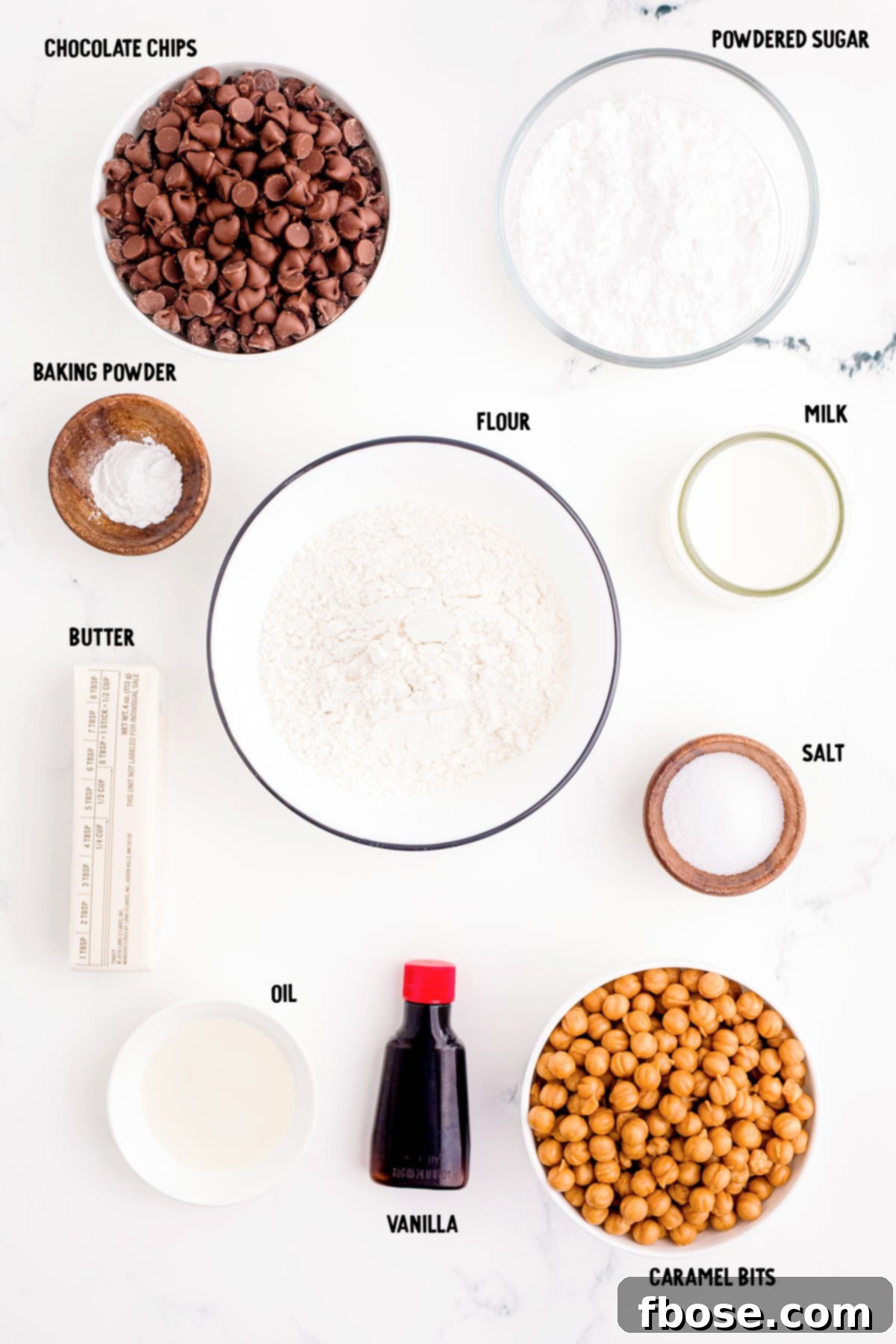 Ingredients prepped to make Twix cookies on a marble counter, neatly arranged and ready for baking.