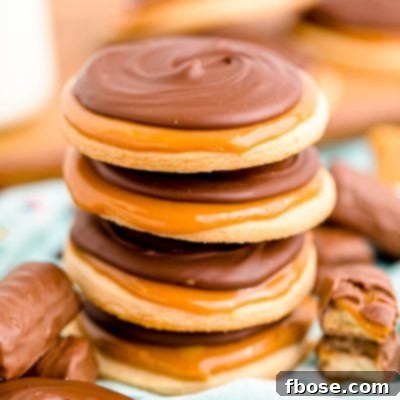 Close up photo of a stack of 4 Twix cookies on a light blue napkin.