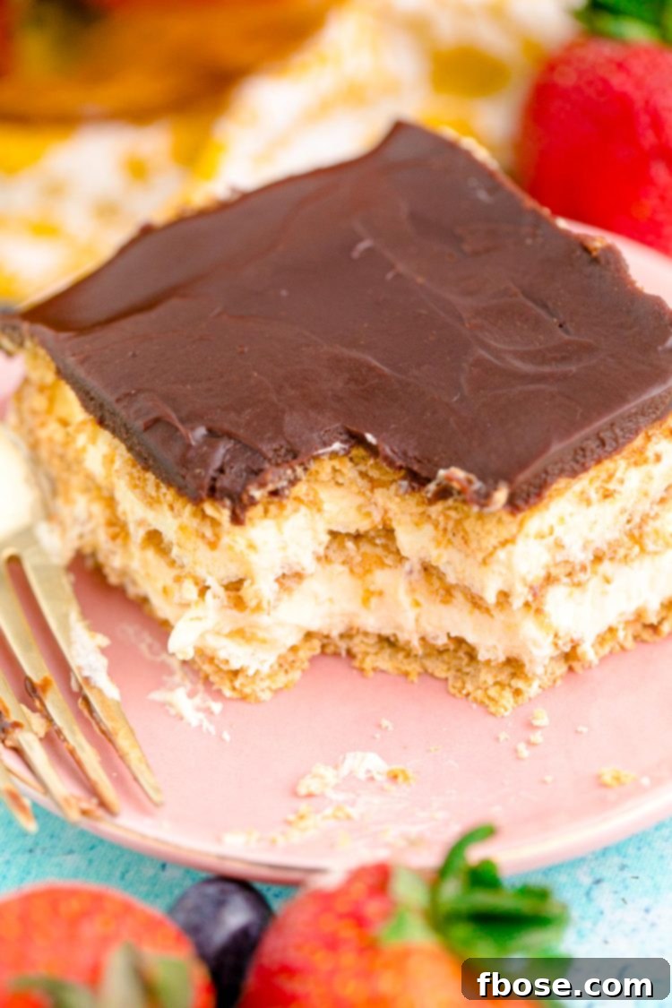 A slice of eclair icebox cake on a pink plate with a bite missing.