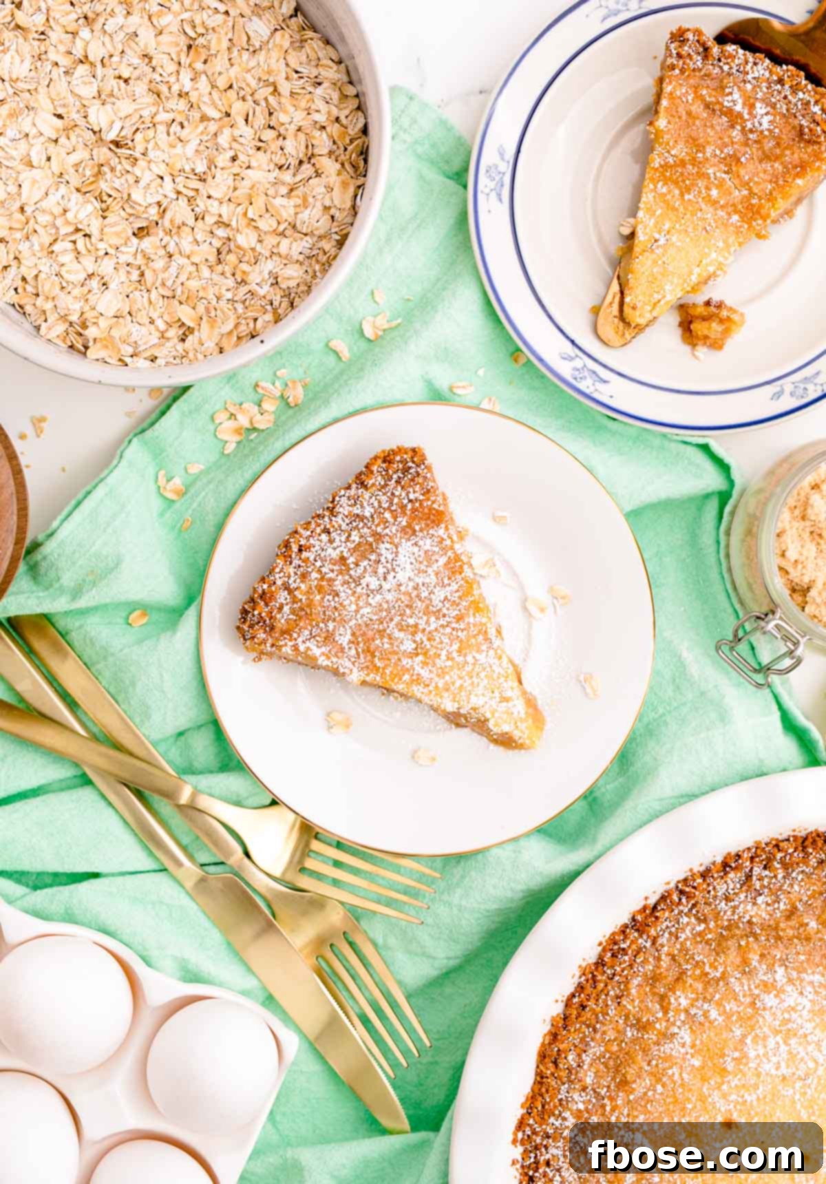 Overhead photo of slices of Milk Bar Pie on white plates on a green napkin, ready for serving.