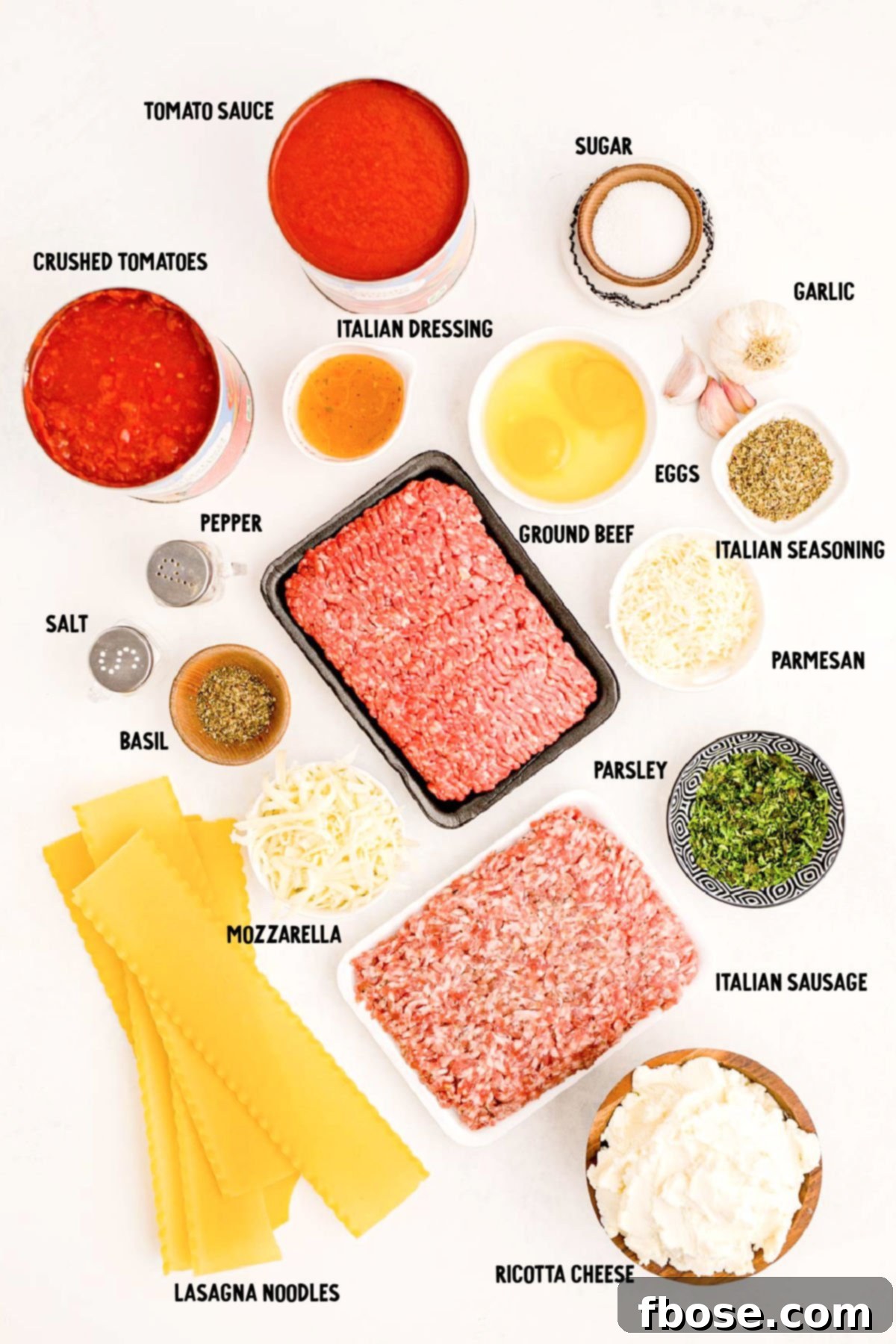 Ingredients to make homemade lasagna prepped on a white table.