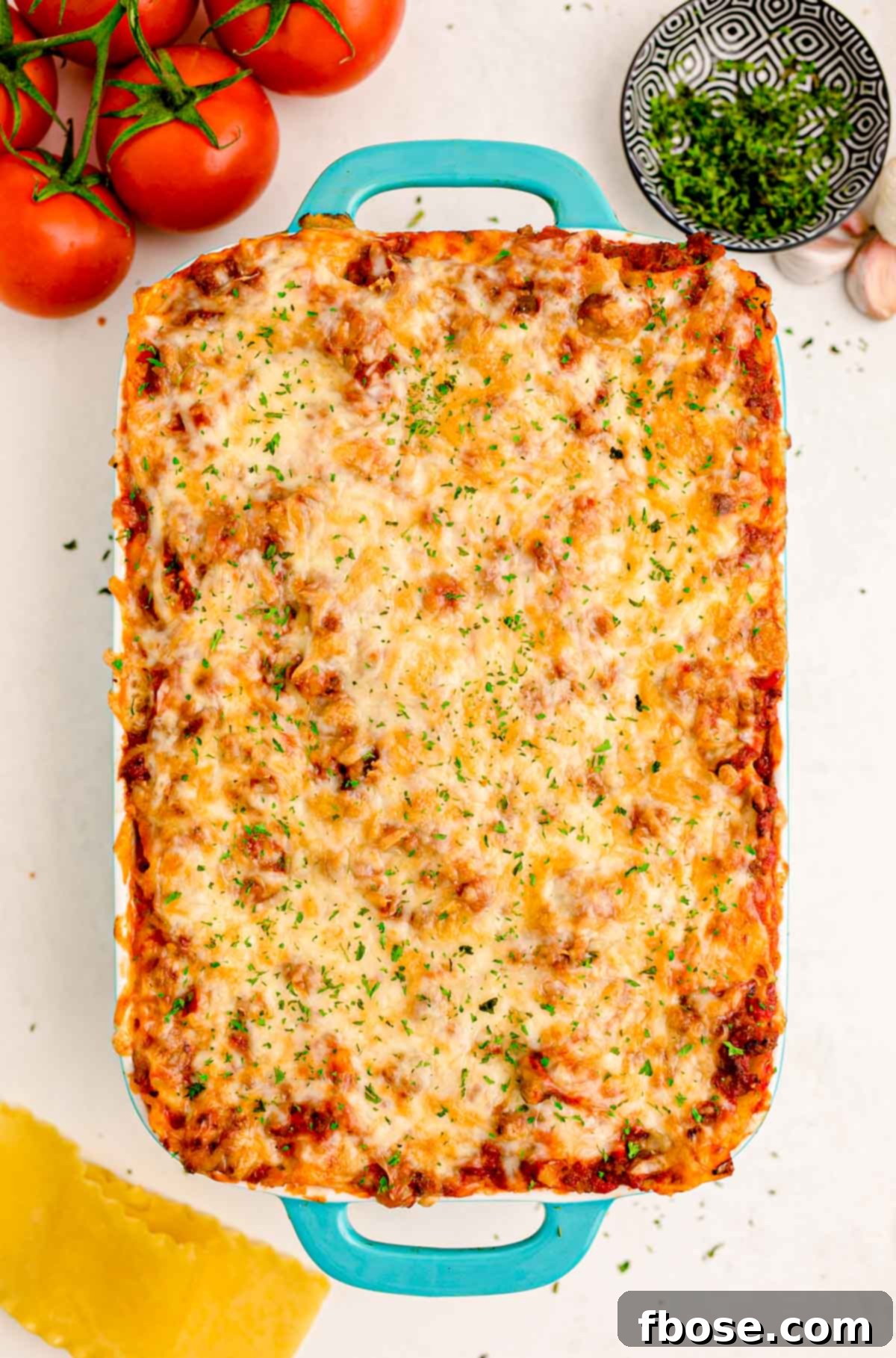 Lasagna in a baking dish on a white table.
