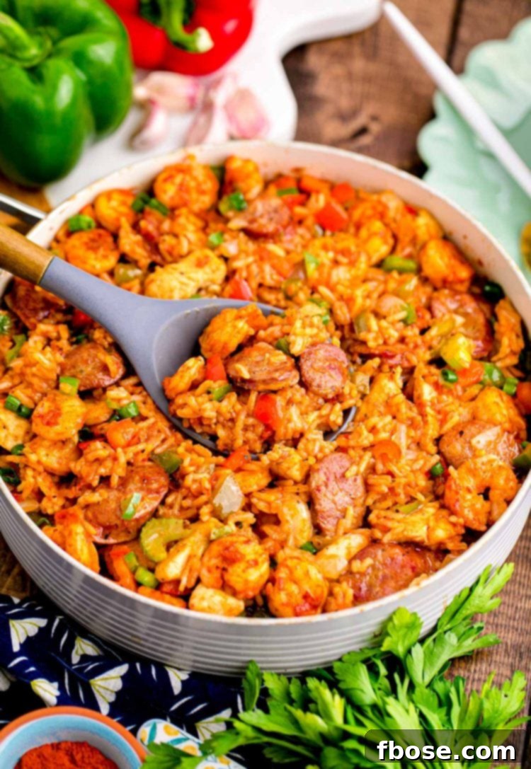 Close up photo of a pan with jambalaya in a pan with ingredients around it.