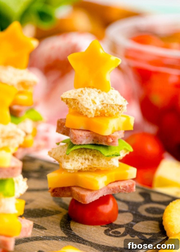 Close up photo of cute Christmas appetizers made with bread, deli meat, and cheese, shaped like mini Christmas trees ready to be served.