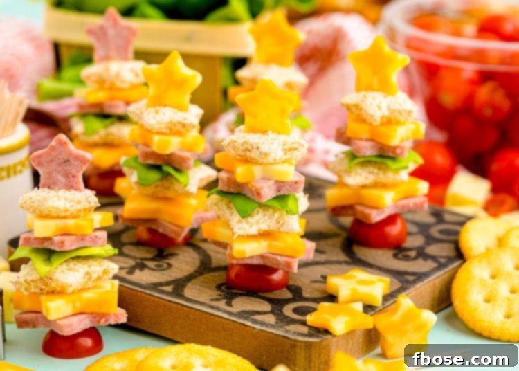 A festive platter of easy Christmas tree shaped appetizers on a wooden cutting board, ready to be enjoyed at a holiday party.