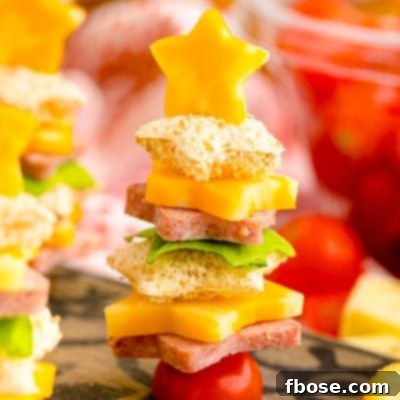 Close up photo of cute christmas appetizers made with bread and deli meat and cheese to look like christmas trees.