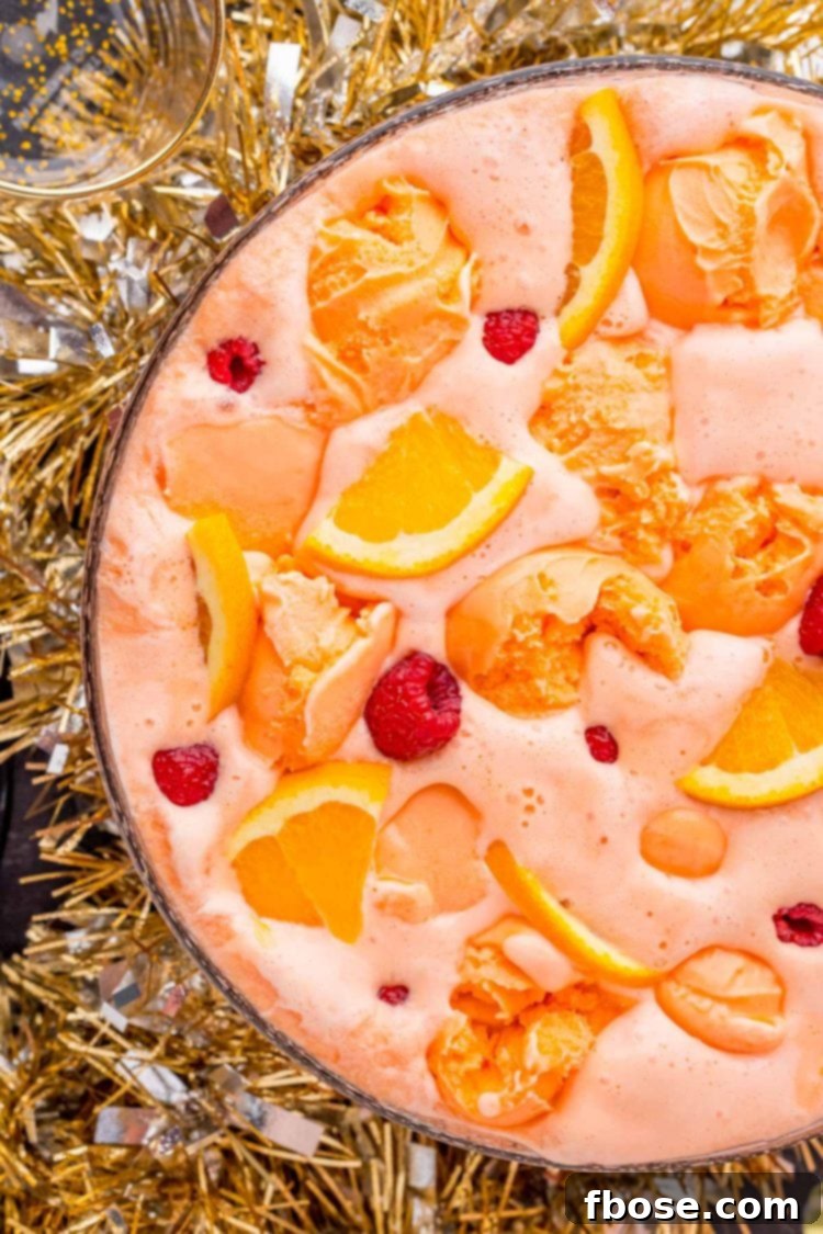 Overhead photo of a bowl of sherbet party punch with tinsel garland around the bottom of the bowl.