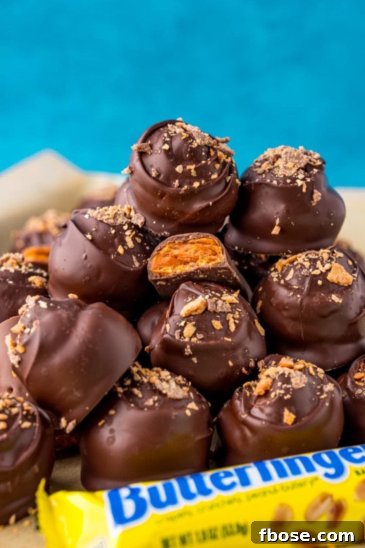Butterfinger balls artfully stacked in a pile, highlighting their crunchy texture and appealing appearance.