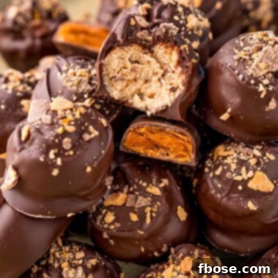 Close up photo of a pile of butterfinger peanut butter balls on a baking sheet.
