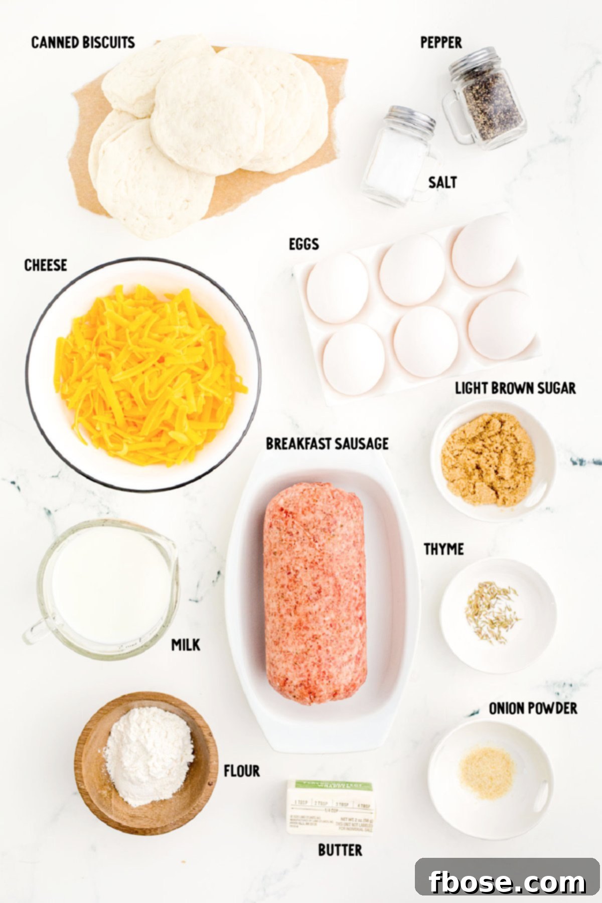 Ingredietns to make biscuits and gravy casserole prepped on a marble counter.