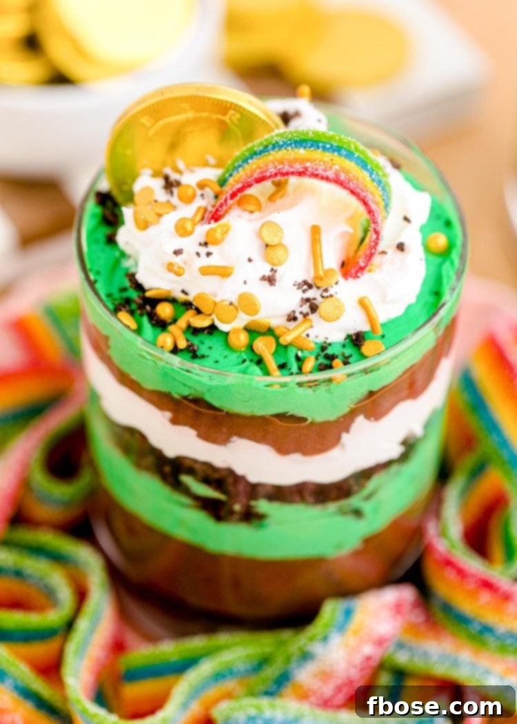 Close up photo of a St Patrick's Day Pudding and Oreo Dessert Cup on a plate with gummy rainbows.